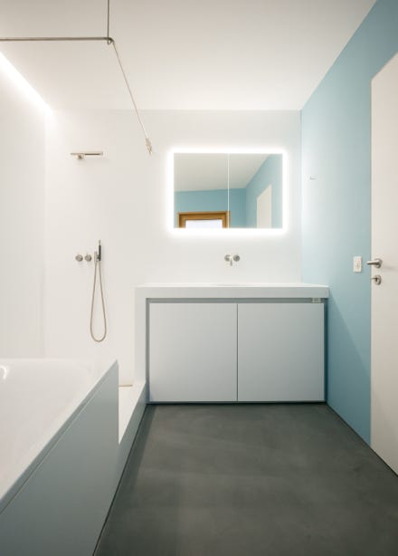 Innenansicht Badezimmer mit Spiegelschrank und Dusche. Hansjörg Betschart Architektur. 