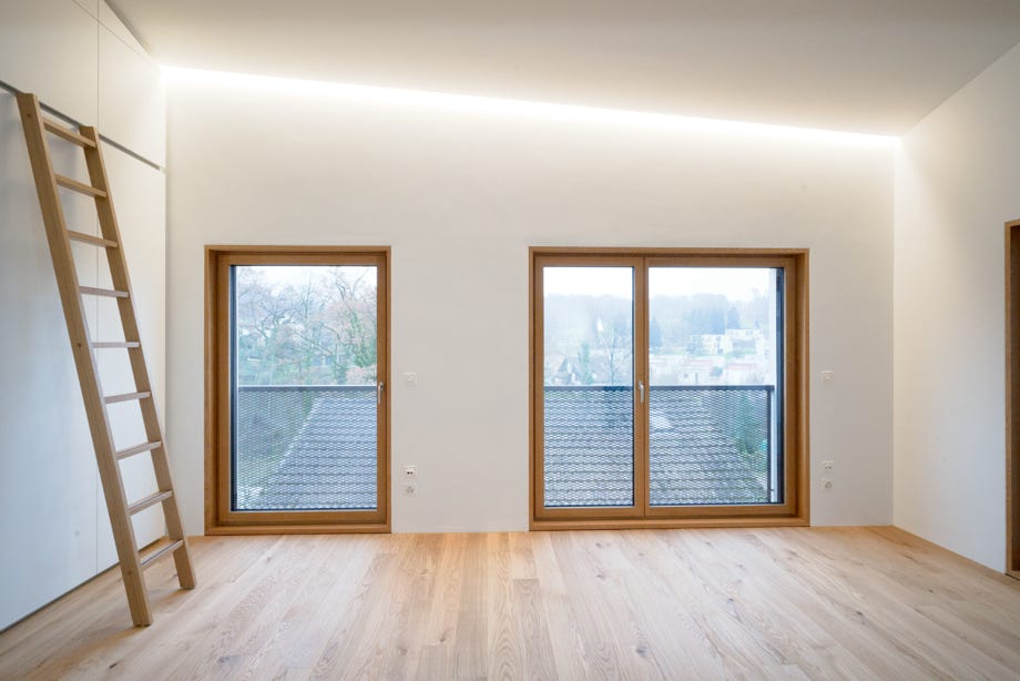 Innenansicht Büro mit zwei Fenster und indirekter Beleuchtung. Hansjörg Betschart Architektur. 