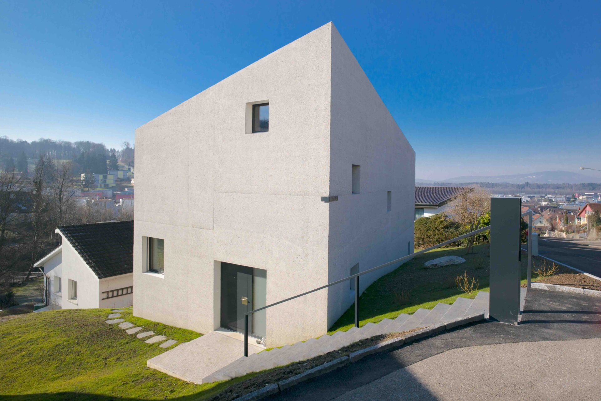 Architetkur-Einfamilienhaus-Eingangsfassade Monolithisches, modernes Einfamilienhauses nahe Bülach - Architektur Hansjörg Betschart