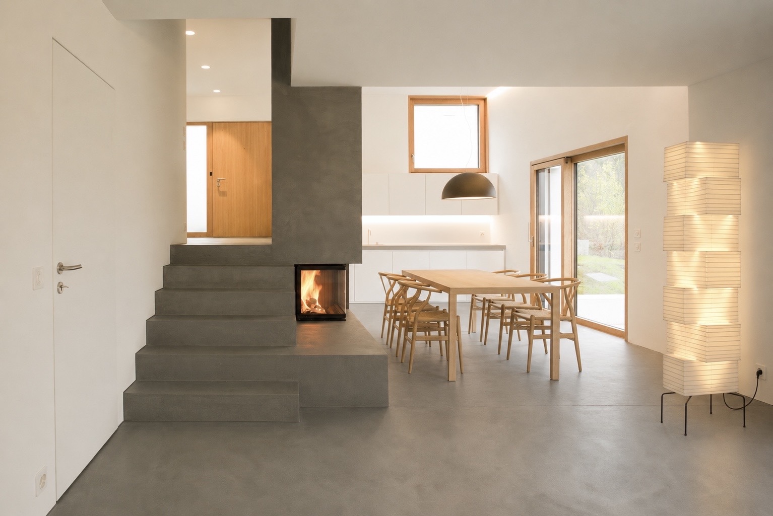 Offener Wohnraum mit Cheminée, Küche und grossen Fensterflächen im modernem Einfamilienhaus nahe Bülach - Architektur Hansjörg Betschart